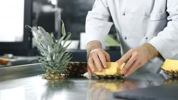 Chef coupe l'ananas à la cuisine. Gros plan mains de chef coupant des fruits sains . — Video