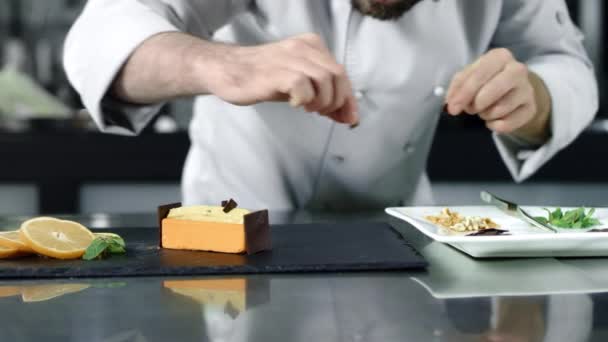 Chef mettere il cioccolato sulla torta al rallentatore. Primo piano panettiere finalizzazione deserto . — Video Stock