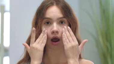 Yüz masajı yapan genç bir kadın. Model kız jimnastik yapıyor.