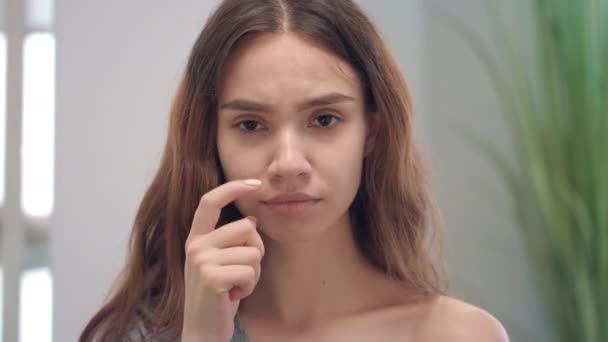Νεαρή αλλεργική γυναίκα ξύνει τη μύτη της μπροστά κάμερας. Γυναίκα που αισθάνεται συμπτώματα γρίπης — Αρχείο Βίντεο