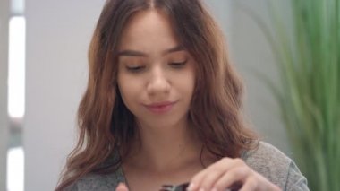 Mutlu kadın banyo odasında öksürüğü iyileştirmek için sıvı şurup içiyor.