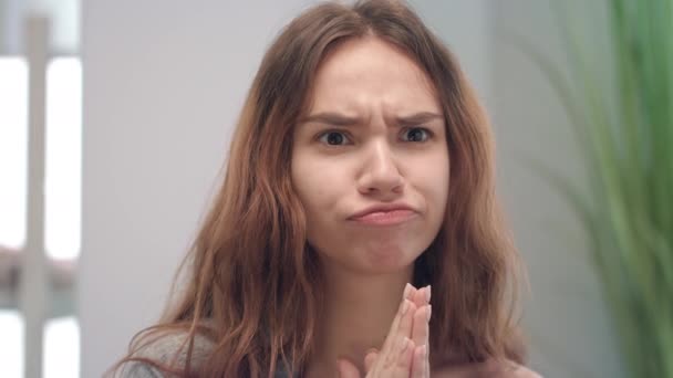 Ung kvinna grimma ansikte och ser att spegla i badrummet — Stockvideo