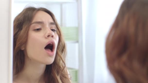 Unhappy woman touching and checking sore throat front bathroom mirror — Stock Video