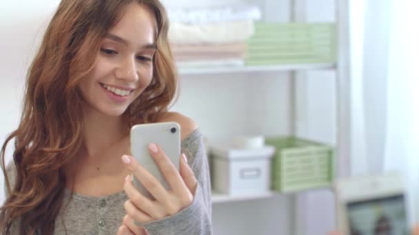 Mujer sonriente tomando foto autofoto móvil en el teléfono en el espejo del baño. Chica feliz — Vídeos de Stock