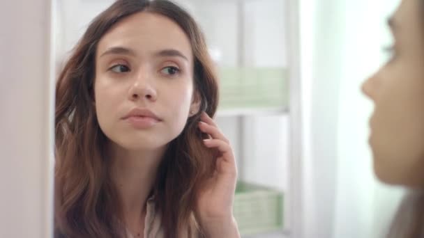 Mulher bonita arrancando sobrancelhas com pinças no espelho no banheiro — Vídeo de Stock