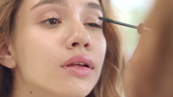 Hübsche Frau Anwendung schwarzer Mascara für Wimpern vor dem Badezimmerspiegel — Stockvideo