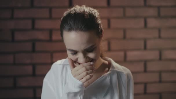 Mujer bonita riendo y escondiendo sonrisa con las manos mientras filma vídeo en el estudio — Vídeos de Stock