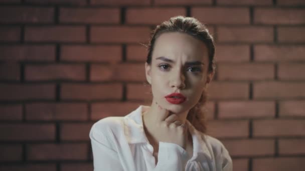 Pensive žena myšlení nápady pózování na cihlové zdi pozadí — Stock video