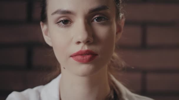 Sexy žena s červenými rty posílání polibek z ruky do kamery na cihlovém pozadí — Stock video