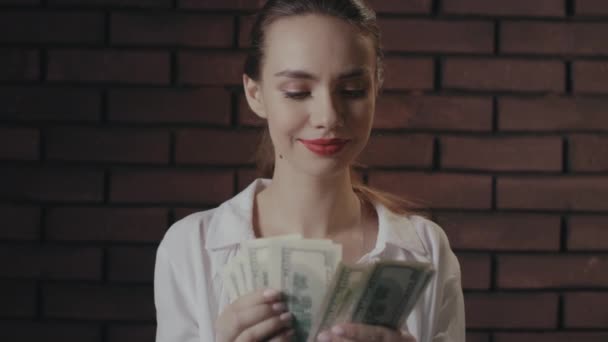 Šťastná žena počítání peněz po vítězství v loterii na cihlové zdi pozadí — Stock video