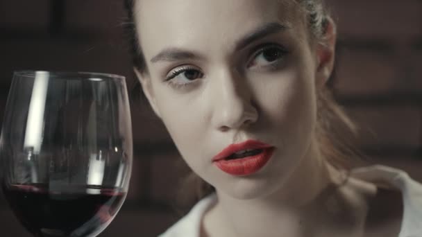 Mujer orgullosa con copa de vino tinto mirando hacia otro lado. Retrato mujer con vino tinto — Vídeos de Stock