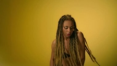 Sarı duvar arka planda dans eden çekici kadın. Portre genç kadın