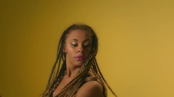 Mujer negra bailando sobre fondo amarillo. Retrato mujer africana bailando — Vídeos de Stock