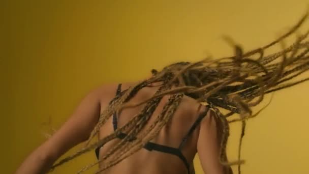 African woman performing modern dance and shaking dreadlocks in dance studio — Stock Video