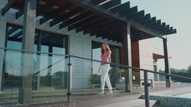 Mutlu kadın lüks eve el sallıyor. Malikanede hoş geldin