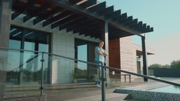Úspěšný muž ubytovaní na terase. Bohatý muž stojící na verandě s luxusními byty. — Stock video