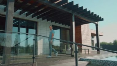 Eve girmeye davet eden mutlu bir adam. Lüks eve gelmek için el sallayan yakışıklı adam