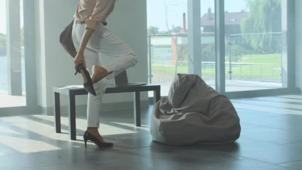 Vermoeide vrouw uitkleden shooes na een harde dag. Beklemtoonde vrouw uitkleden schoeisel — Stockvideo