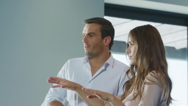 Fröhliches Paar bei der Planung des Interieurs. Menschen sprechen im modernen Interieur — Stockvideo