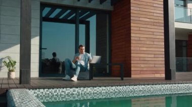 Zengin bir evde dizüstü bilgisayar üzerinde çalışan iş adamı. Kablosuz teknolojiyi kullanan adam