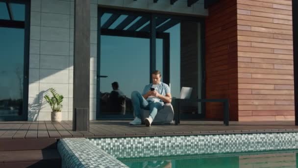 Casual man resting with mobile phone. Handsome man using mobile at luxury house — Stock Footage Casual man resting with mobile phone. Handsome man using mobile at luxury house Royalty Free Stock Video