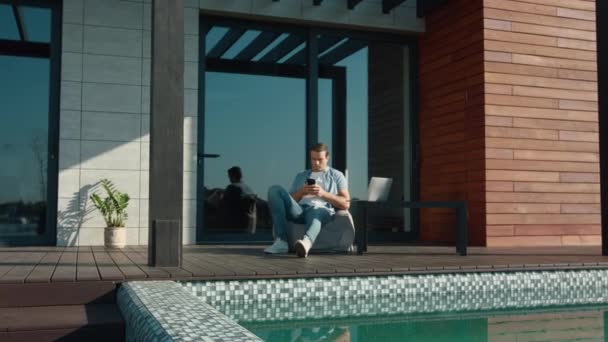 Casual man resting with mobile phone. Handsome man using mobile at luxury house — Stock Video