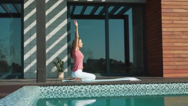 Pebisnis wanita melakukan yoga dekat kolam renang. Perempuan relaks membuat pose anak . — Stok Video