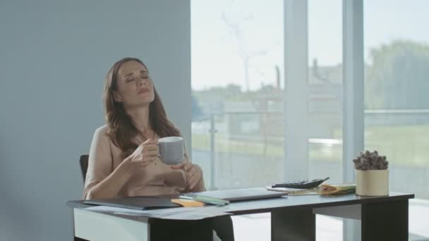 Επιχείρηση γυναίκα χαλαρώνει με τον καφέ. Κουρασμένη κυρία που κάθεται με φορητό υπολογιστή. — Αρχείο Βίντεο