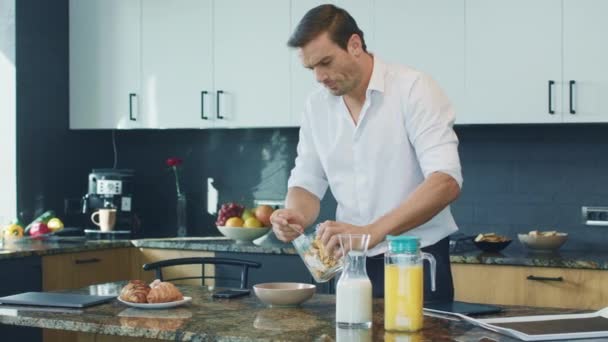 Uomo d'affari che prepara la colazione in cucina. Controllo professionale del telefono cellulare . — Video Stock