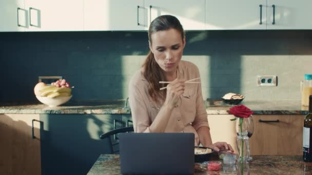Красива жінка їсть суші в розкішному будинку. Жінка дивиться ноутбук . — стокове відео