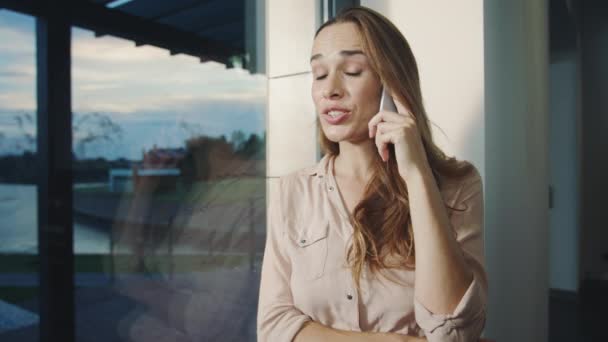 Evde mobil konuşan mutlu bir kadın. Gülümseyen kadının telefon konuşması portresi. — Stok video