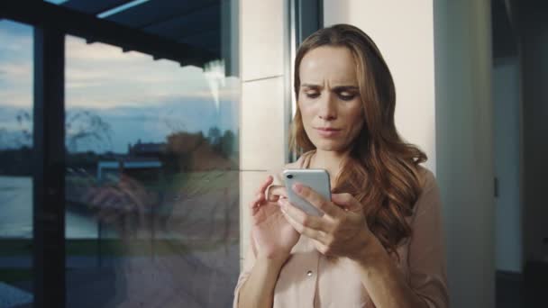 Lycklig kvinna ser mobiltelefon nära. Leende kvinna rullning smartphone. — Stockvideo