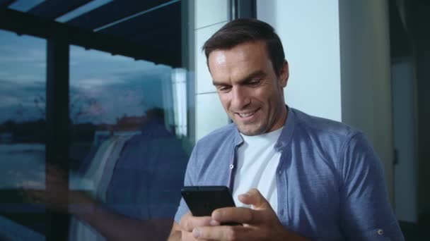 Homem feliz à procura de telemóvel. Bonito homem olhando foto no celular . — Vídeo de Stock