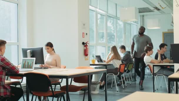 Serieuze man komt in coworking ruimte. Black man van plan om te werken in open ruimte. — Stockvideo