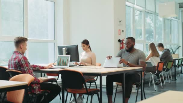 Hombre negro terminando el trabajo en el espacio de coworking. Hombre serio cierre ordenador portátil — Vídeos de Stock