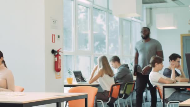 Hombre africano entrando en el espacio de coworking. Primer plano hombre serio apertura portátil . — Vídeos de Stock