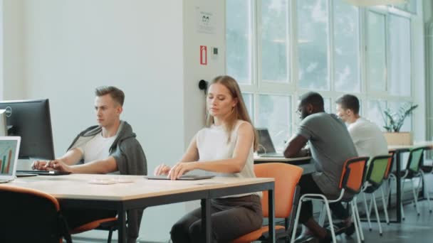 Mujer concentrada terminando el trabajo en coworking. Freelancer serio con notebook — Vídeos de Stock