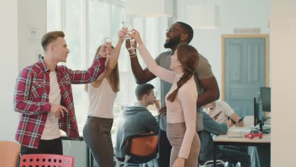 Весела команда святкує успіх на робочому місці. Щасливі друзі п'ють алкоголь . — стокове відео