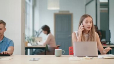 Kızgın kadın işyerinde mobil konuşuyor. Sinirli kadın telefon görüşmesi yapıyor.