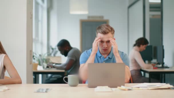 Seriöser Mann, der am Arbeitsplatz Computer guckt. männliche Person liest schockierte Nachrichten — Stockvideo