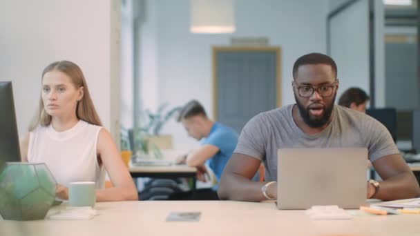 Homem africano feliz lendo boas notícias no computador portátil no espaço de coworking — Vídeo de Stock