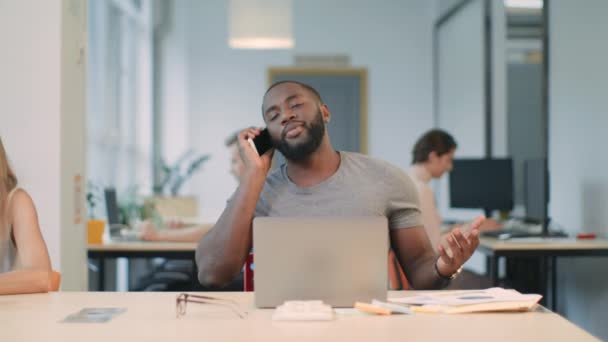 コワーキングスペースで電話を話す幸せなビジネスマン。電話を持つ若い男 — ストック動画