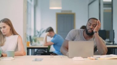 Yorgun adam iş yerinde uykulu hissediyor. Siyah adamın uykuya dalan portresi.