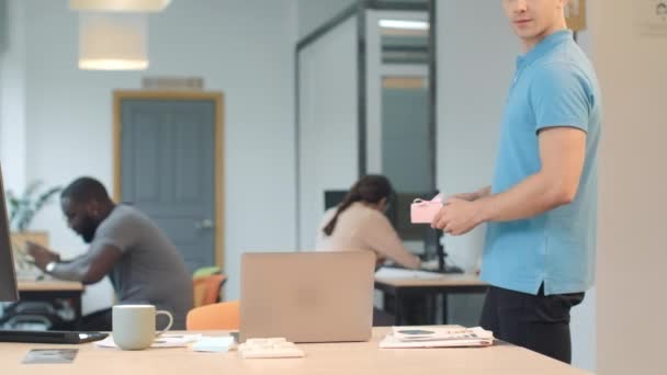 Hombre romántico dejando regalo en el coworking. Guapo chico entregando beso — Vídeo de stock