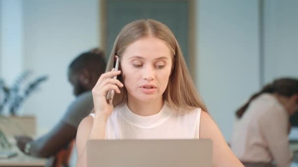 Rozzlobená žena křičící v mobilním telefonu ve spolupracovním prostoru — Stock video