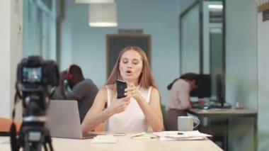 Güzel kadın video kaydediyor. Kadın vlogger iki telefon farkı sunan