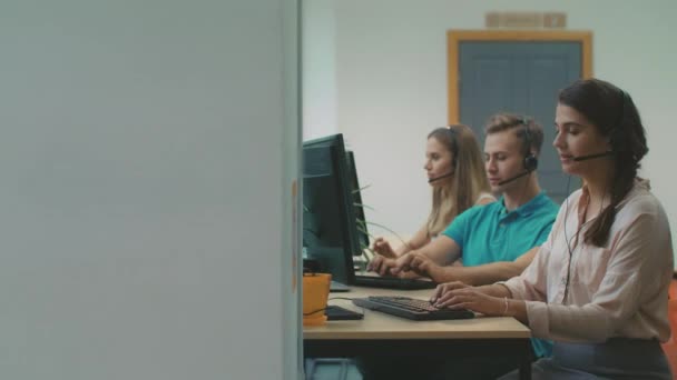 Mujer joven hablando con clientes en coworking. Trabajador cansado lanzando auriculares . — Vídeo de stock