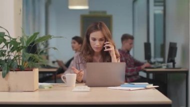 Cep telefonu konuşan ciddi bir kadın. Sorunları çözmeye çalışan üzgün işçi.
