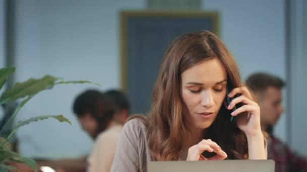 Una mujer seria recibiendo una llamada telefónica. Persona enojada discutiendo agudamente por teléfono . — Vídeos de Stock