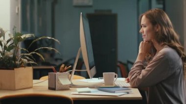 İş kadını gece coworking alanda bilgisayarda mali rapor arıyor